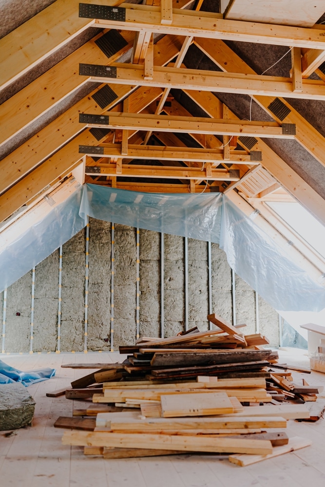 Isolation des combles et charpente bois apparente Aménagement de combles avec isolation en laine minérale, pare-vapeur bleu et charpente bois apparente.